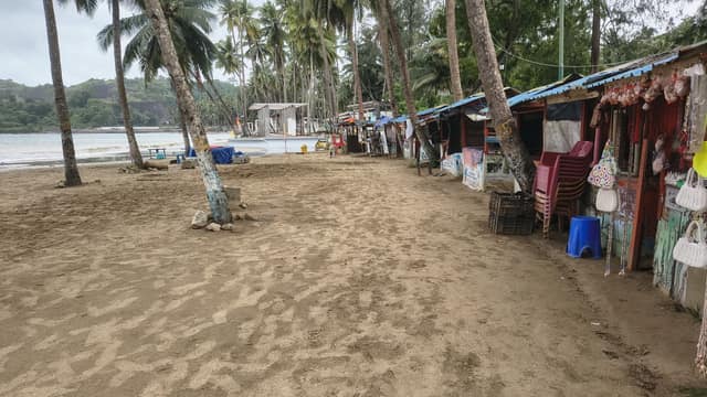 Palm-lined sand and beach shacks at Corbyn's Cove, Port Blair