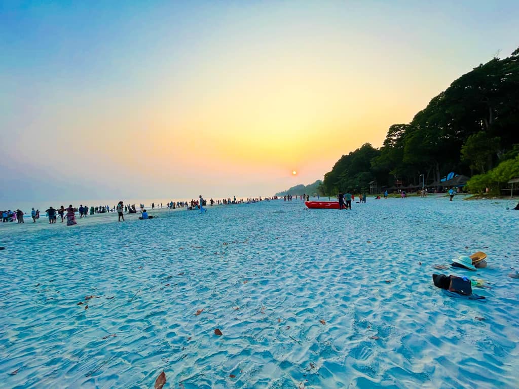 Golden hour at Radhanagar Beach with the day-trip crowd spread along two kilometres of sand