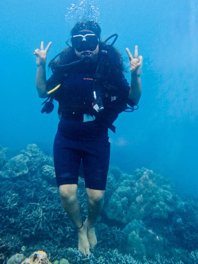 A scuba diver over live coral in clear Andaman water